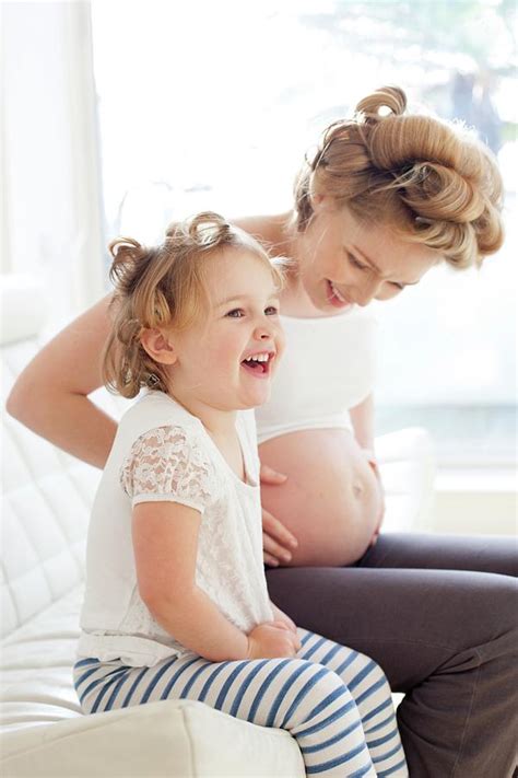 pregnant woman and daughter smiling photograph by ian hooton science photo library fine art