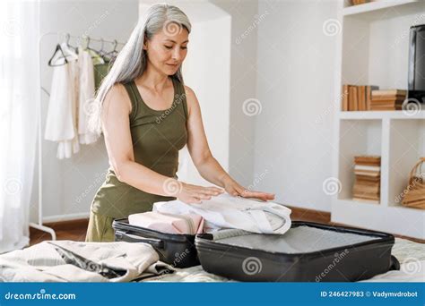 Mature Asian Woman With Grey Hair Packing Suitcase At Home Stock Image Image Of Suitcase