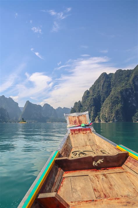 A Boat Is Traveling On The Water With Mountains In The Background