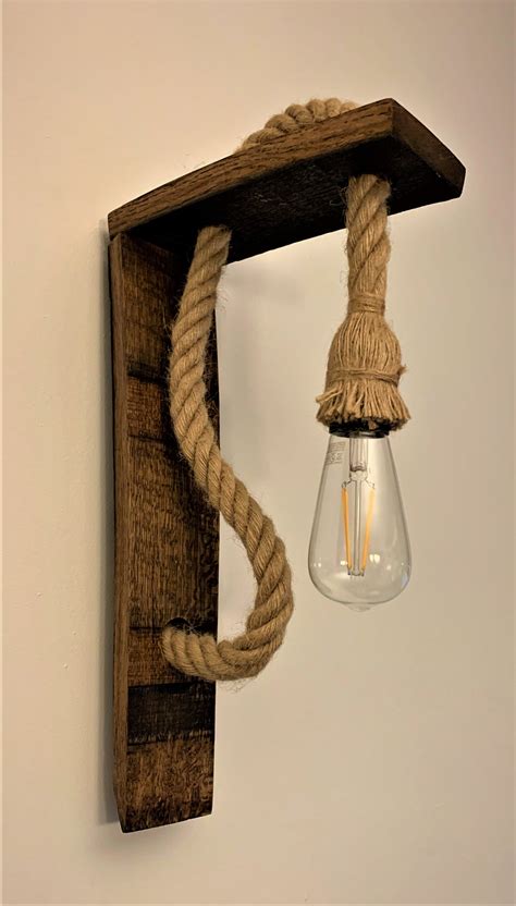 A Light That Is Hanging From A Wooden Frame With Rope On The End And An