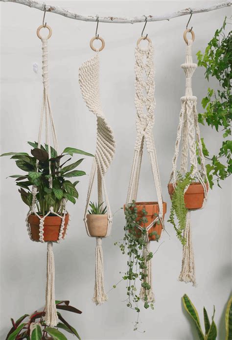 Macrame Plant Hangers With Plants In Them On A White Wall Next To