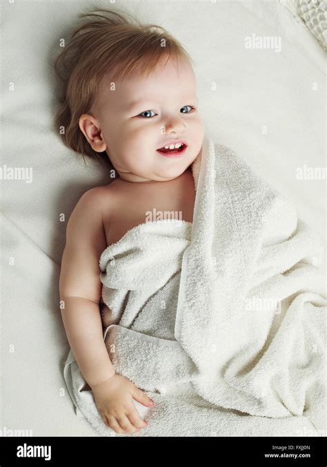 One Year Old Baby In Bed With Towels After Taking A Bath Stock Photo