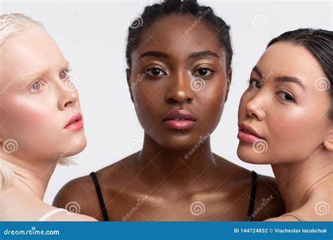African American Woman Standing Between Women With Light Skin Stock