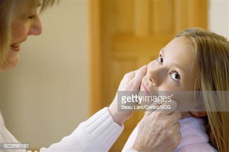 Woman Pinching Cheeks Of Girl High Res Stock Photo Getty Images