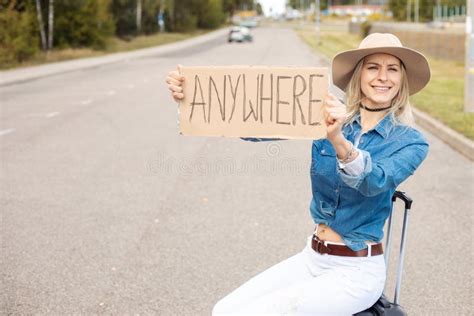 Funny Laughing Cheerful Carefree Blond Woman Sit In Cowgirl Hat And Jeans Shirt Hitchhiking