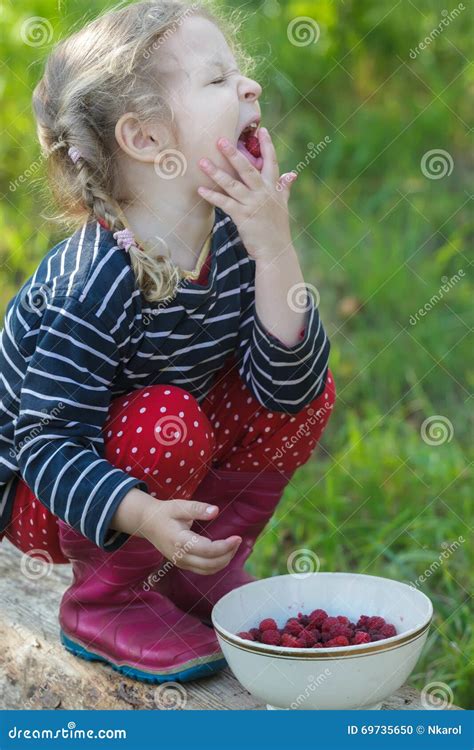 Braided Blonde Little Girl Bringing Hand To Mouth And Enjoying Of