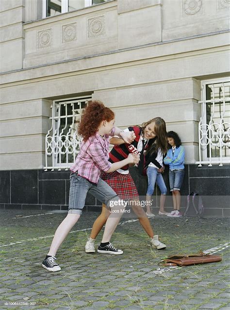 Two Teenage Girls Mockfighting Outside School Foto De Stock Getty Images