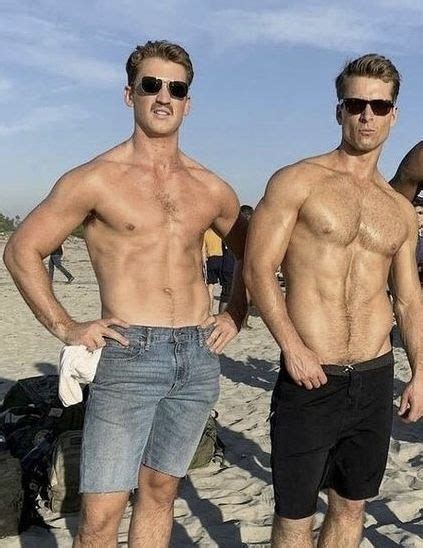 Two Men Standing Next To Each Other On A Beach