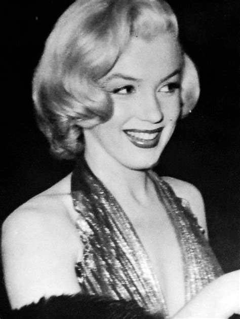 A Black And White Photo Of A Woman With Blonde Hair Smiling At The
