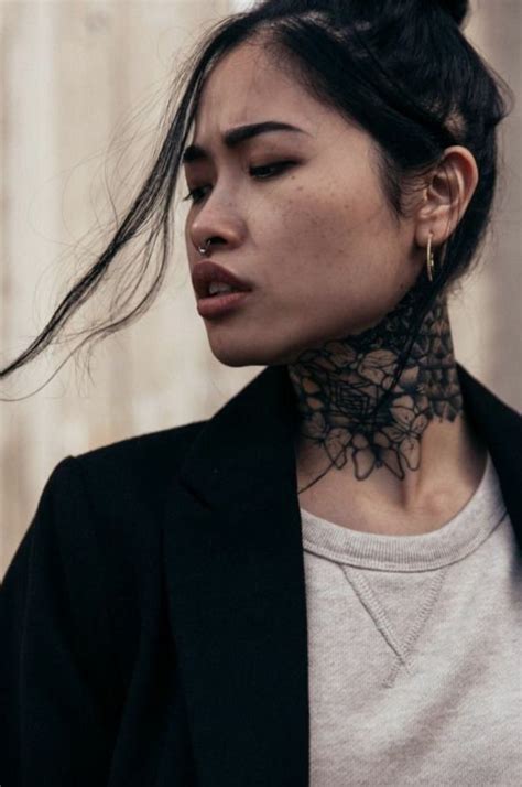 A Woman With Tattoos On Her Neck Wearing A Black Blazer