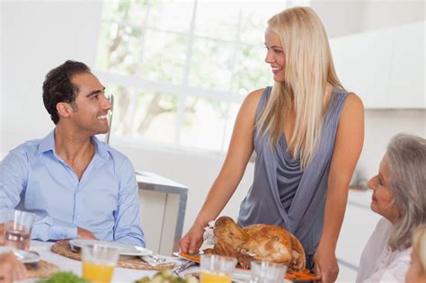 Happy Wife Bringing Turkey To The Table At Thanksgiving