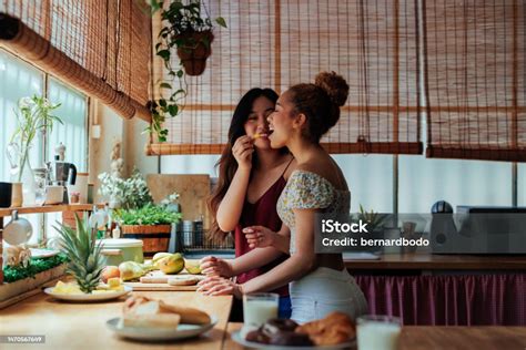 Beautiful Lesbians Eating Fruit And Having Fun In The Kitchen Stock