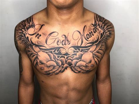 A Man With A Chest Tattoo That Says God S Name On His Chest And Wings