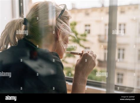 Mature Woman Smoking E Cigarette At Home Near The Window Caucasian 40