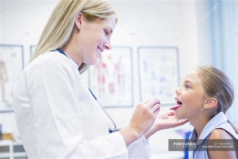 Female Doctor Examining Young Girl Tongue — Interior Equipment