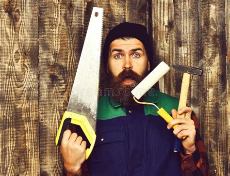 Bearded Builder Holding Various Building Tools With Surprised Face