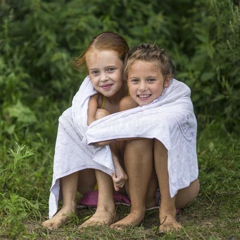 Dwa Niegrzecznej Małej Dziewczynki Siedzi Na Plaży W Ręczniku Po Kąpać W Jeziorze Lato Zdjęcie
