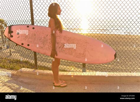 Mädchen Am Strand Hält Rosa Surfbrett Stehend Stockfotografie Alamy