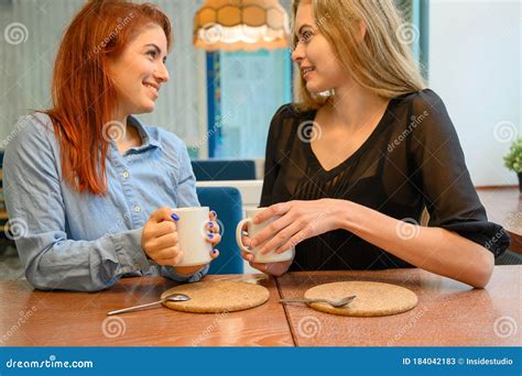 Lesbian Couple Of Women On A Date In A Cafe Two Happy Girlfriends Drink Coffee And Chat In A
