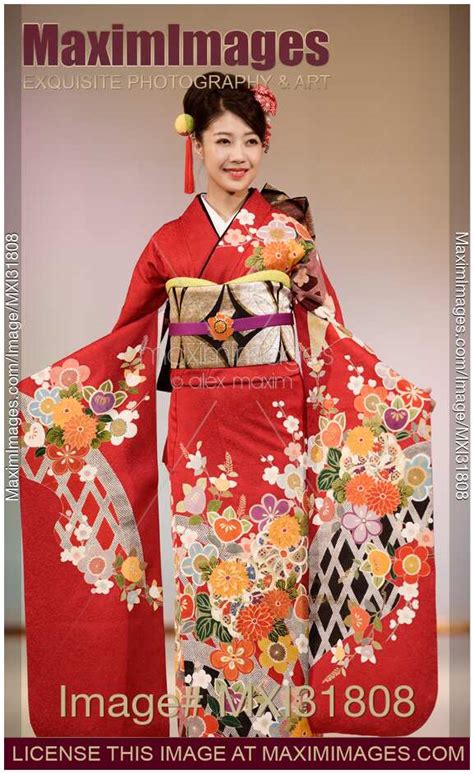 photo of japanese woman in a beautiful red kimono with a colorful pattern at a fashion show in