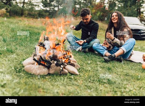 Beautiful Couple Roasting Marshmallows Over The Campfire Stock Photo