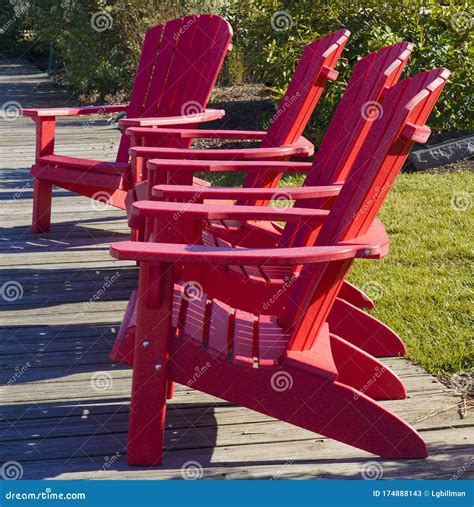 Four Bright Red Adirondack Chairs Sitting Pier Facing Same Direction Four Red Adirondack Chairs 174888143 