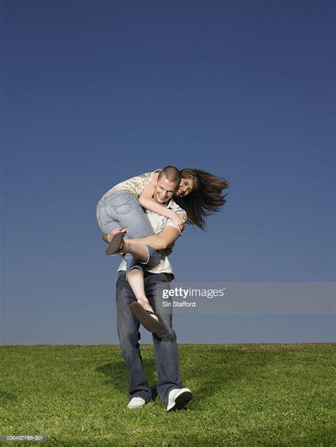 Young Man Carrying Woman Over Shoulder High Res Stock Photo Getty Images