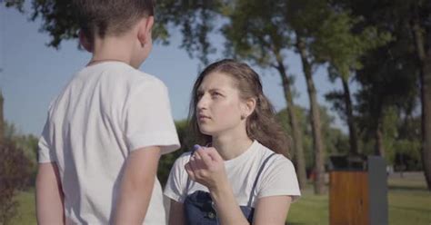 Strict Older Sister Scolding Her Younger Brother In The Summer Park By