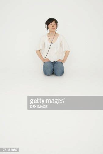 Young Woman Kneeling And Listening To Music Stock Foto Getty Images