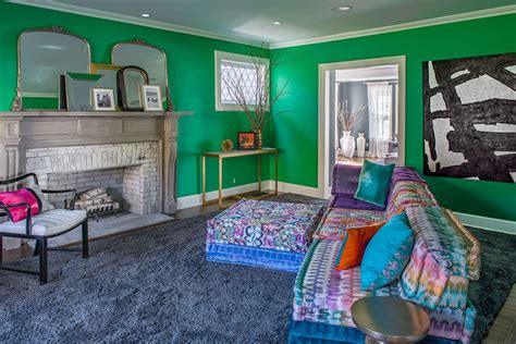 It looks awesome when combined with gray, so check out the living room in these two gorgeous colors. living room, green wall, colorful couch, bright colors, mirrors, fireplace, Carrie McCall Desi ...