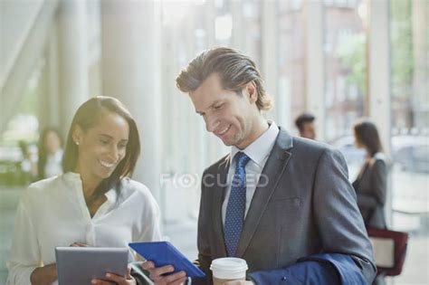 Business People Using Digital Tablets In Office Lobby — Wireless