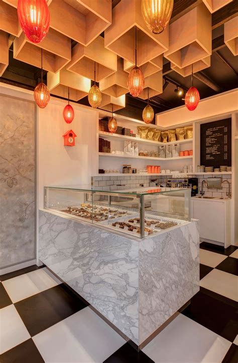 The Interior Of A Bakery With Marble Counter Tops And Lights Hanging