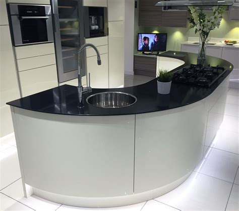 Gloss Ivory Kitchen Island With Large Curved Units And Black Glass