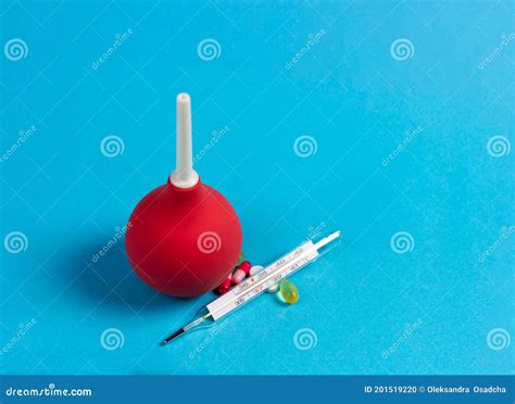 Enema Mercury Thermometer And Medical Pills On A Blue Background