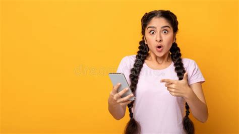 Surprised Indian Woman Using Mobile Phone Pointing At Gadget Stock