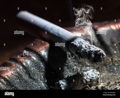 The Cigarette Emitting Smoke Burning In An Ashtray Stock Photo Alamy