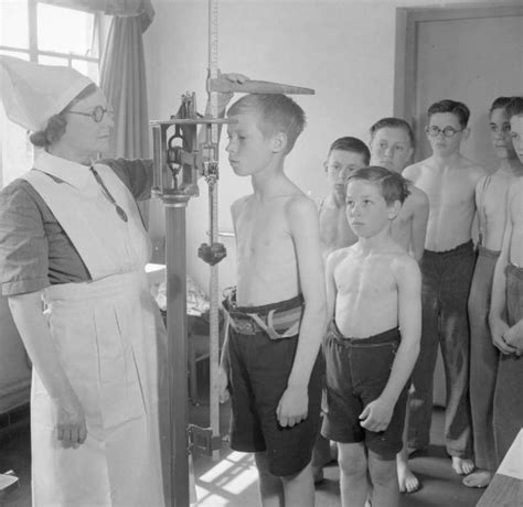 Boys Are Measured By The School Nurse During A Medical Inspection At