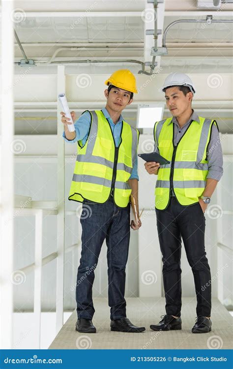 Two Engineers In Yellow Reflective Vest And Wearing Safety Hardhat