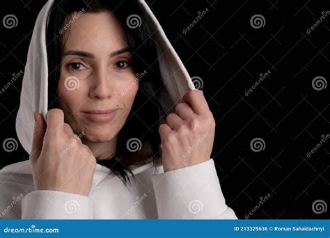 Portrait Of Beautiful Mature Brunette Woman Dressed In White Hoodie Isolated On Black Background