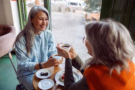 mature women enjoy hot drinks at cozy cafe photo background and picture for free download pngtree