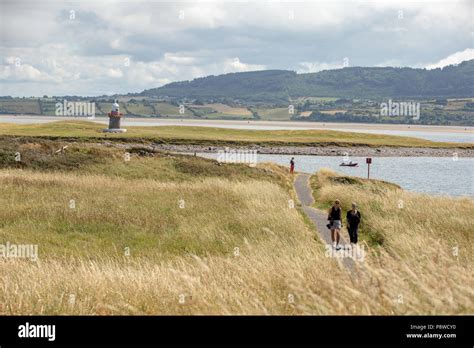 Tourists Walking Along The Rosses Point Coastal Way Trail With Oyster