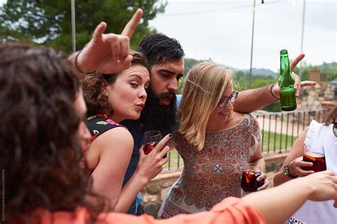 Adults With Drinks Having Fun In Garden At Party By Stocksy Contributor Guille Faingold