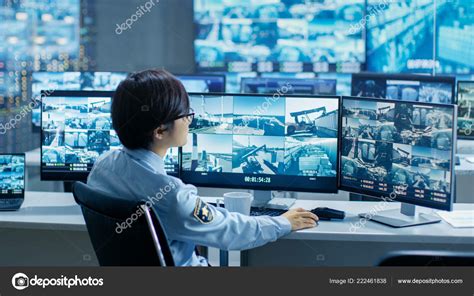 Security Control Room Officer Monitors Multiple Screens Suspicious