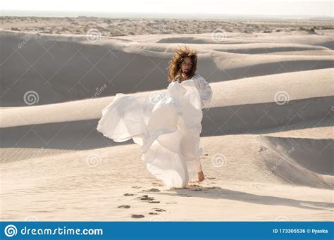 Beautiful Brunette Curly Hair Girl Running In White Dress On Desert