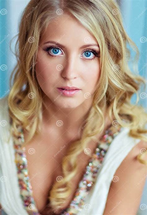 Very Beautiful Blond Woman With Long Curly Hair And Blue Eyes Stock