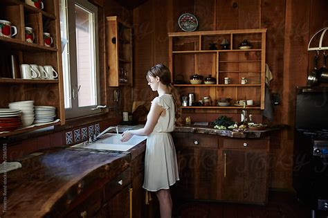 Woman At Sink In Log Cabin By Trinette Reed Stocksy United