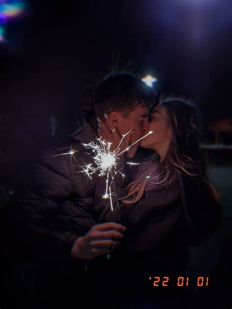 A Man And Woman Kissing While Holding Sparklers