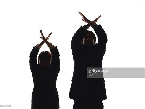 Portrait Of Businessman And Businesswoman Crossing Arms Above Heads