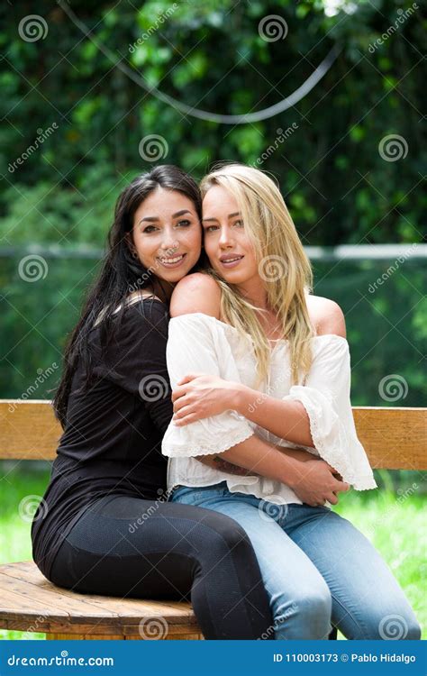 A Pair Of Proud Lesbian In Outdoors Sitting On A Wooden Table Brunette
