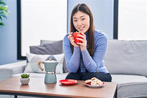 Chinese Woman Having Breakfast Sitting On Sofa At Home Stock Image